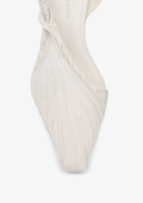 Coppelia 50 slingback by Boutashkova, a close-up of a white pointed-toe high heel with a textured fabric upper and a twisted detail at the ankle, shown on a light gray background.